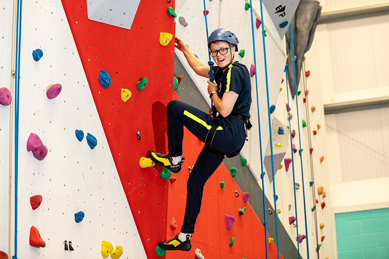 Student scales the College climbing wall
