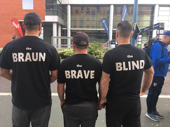 Team QAC runners pose with their backs to the camera revealing their nicknames on the back of their shirts