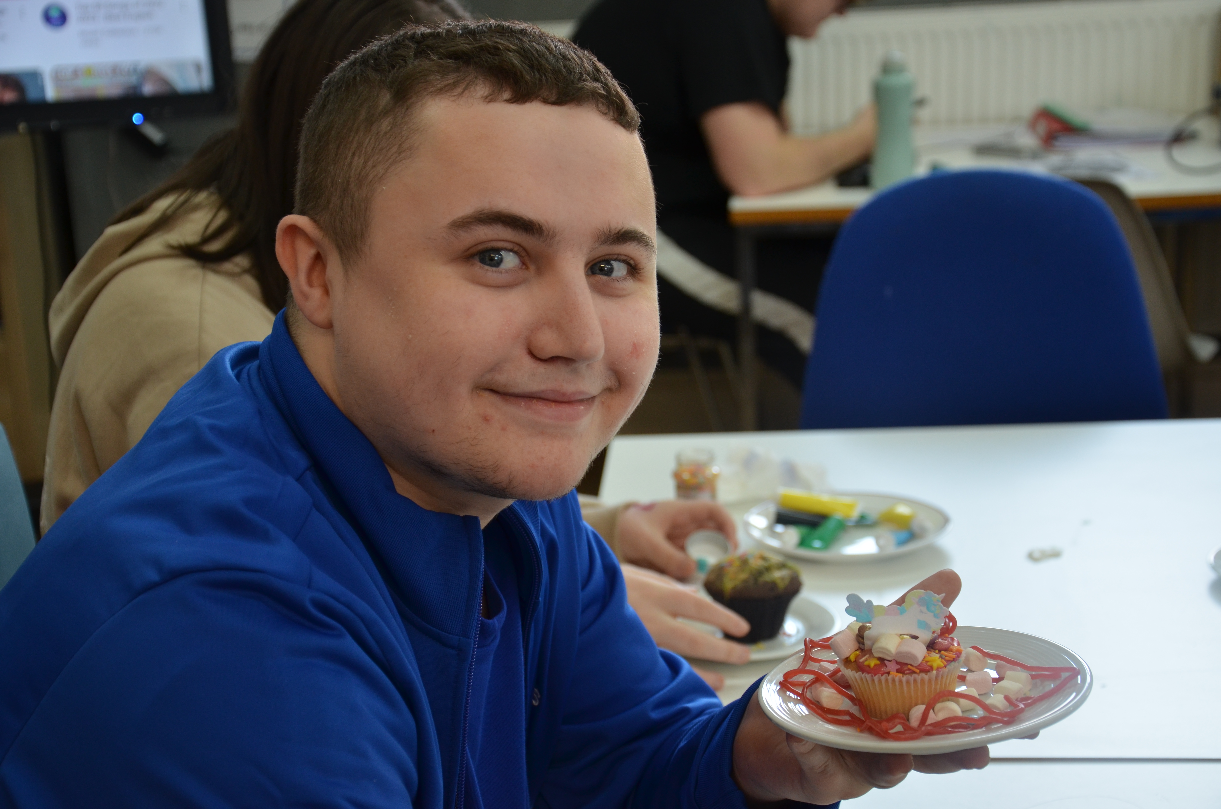 QAC student holding his decorated cake