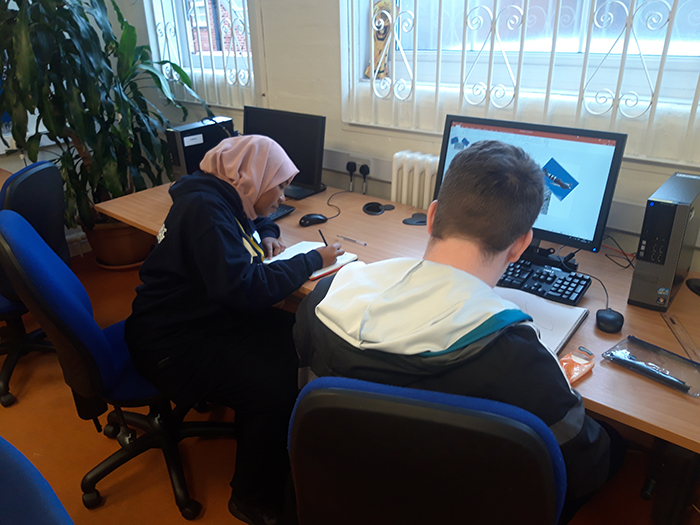 Enactus students works on a task with a LEAP Creative student