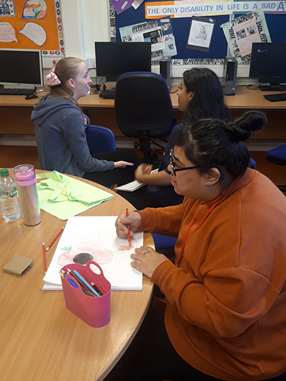 Enactus student works in a group with LEAP Creative students