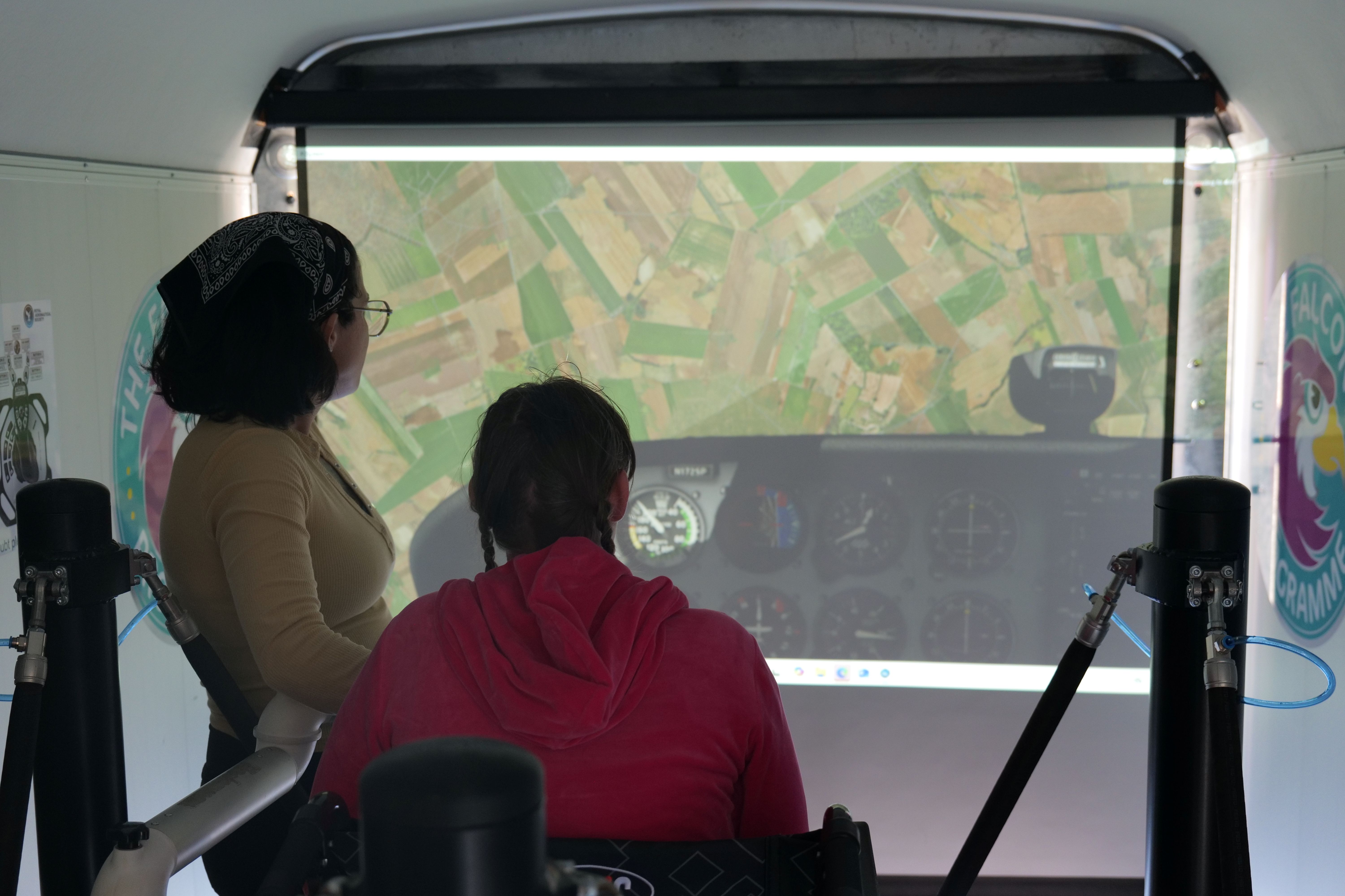 Image of a student and staff using the simulator