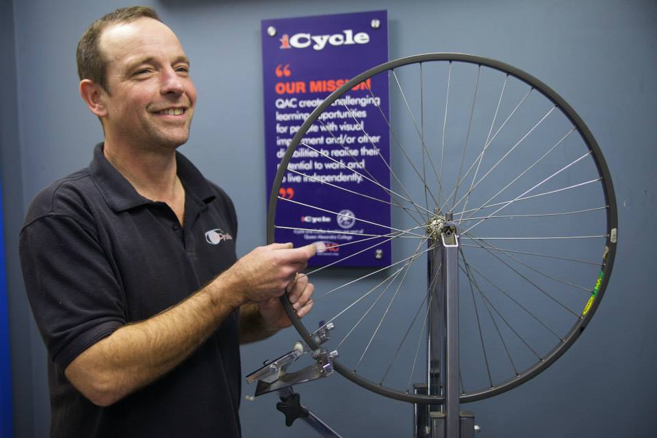 A member of the iCycle team repairs a bike wheel. 