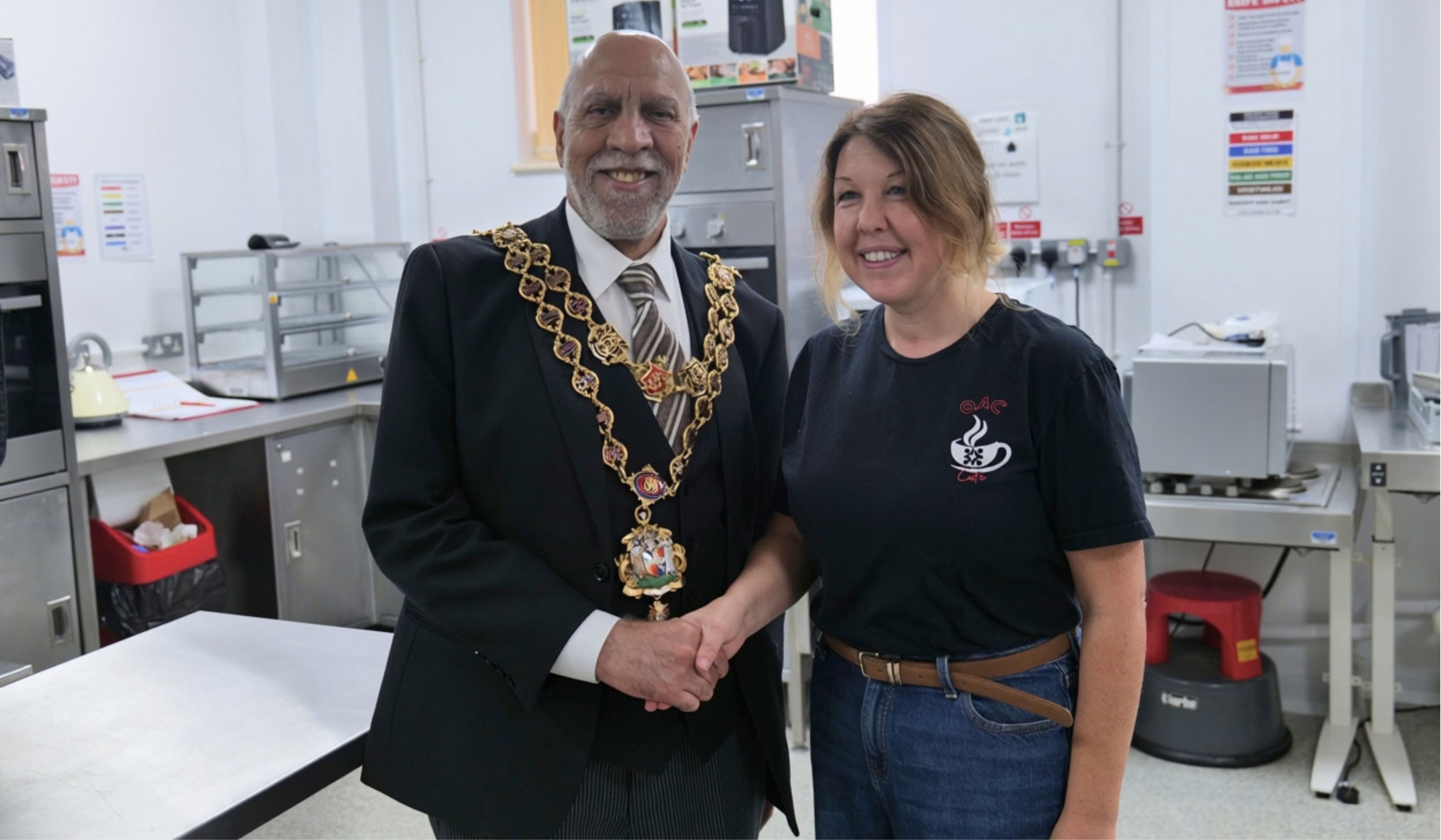 Lord mayor shaking hands with staff member in a commercial kitchen Lord mayor shaking hands with staff member in a commercial kitchen