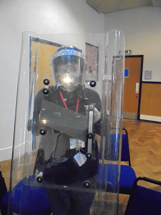 Another QAC student happy to try on Police riot gear Another QAC student happy to try on Police riot gear