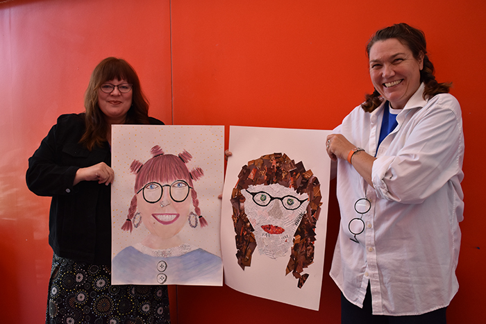 Bev and Jan pictured together holding their completed portraits of one another