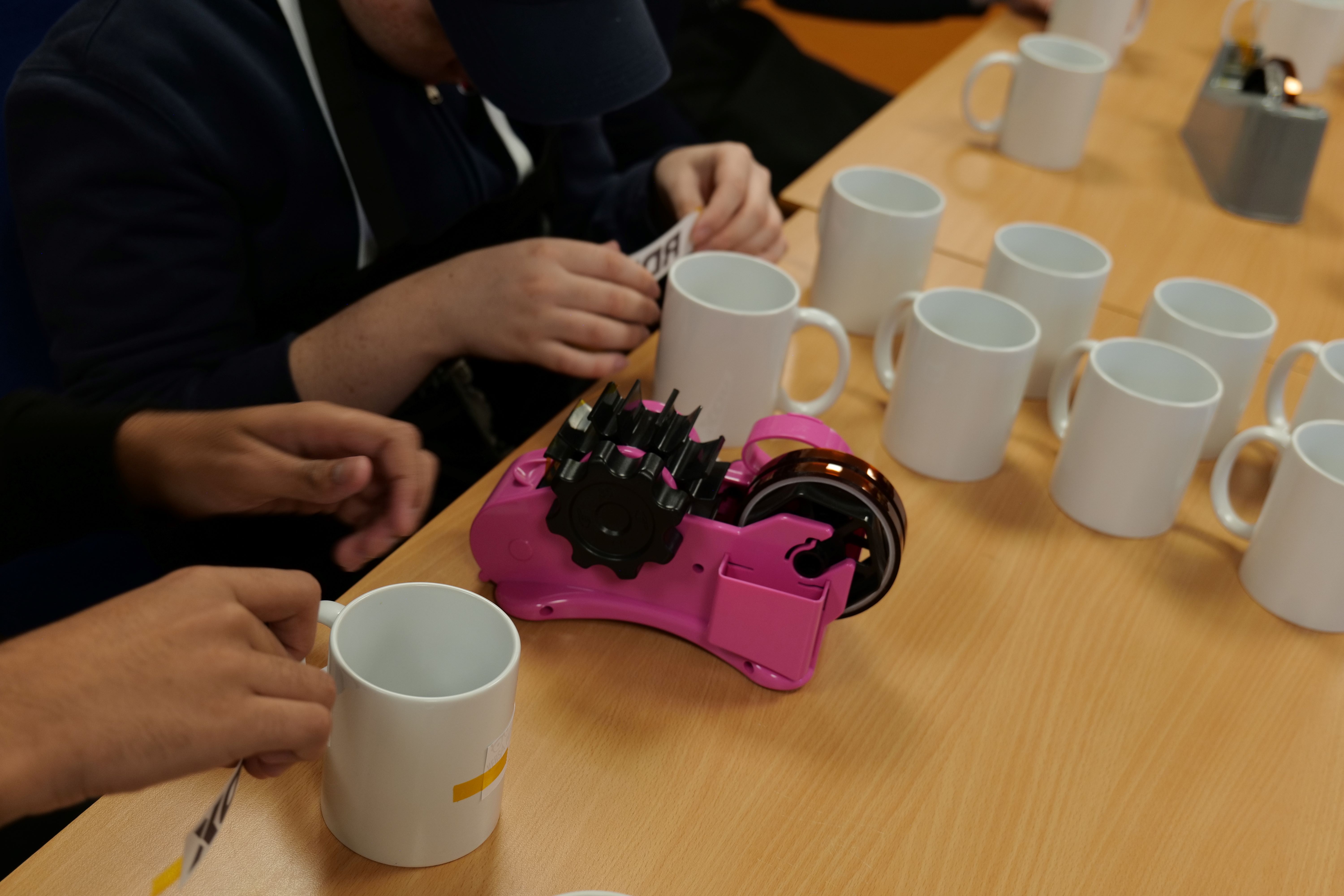 Students printing onto mugs Students printing onto mugs