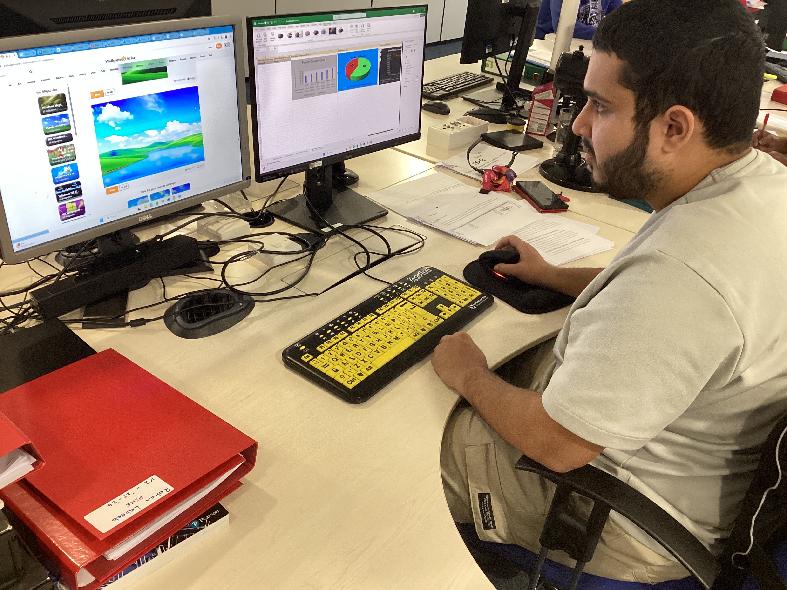 Rohan looking at his computer screen using a black and yellow keyboard Rohan looking at his computer screen using a black and yellow keyboard