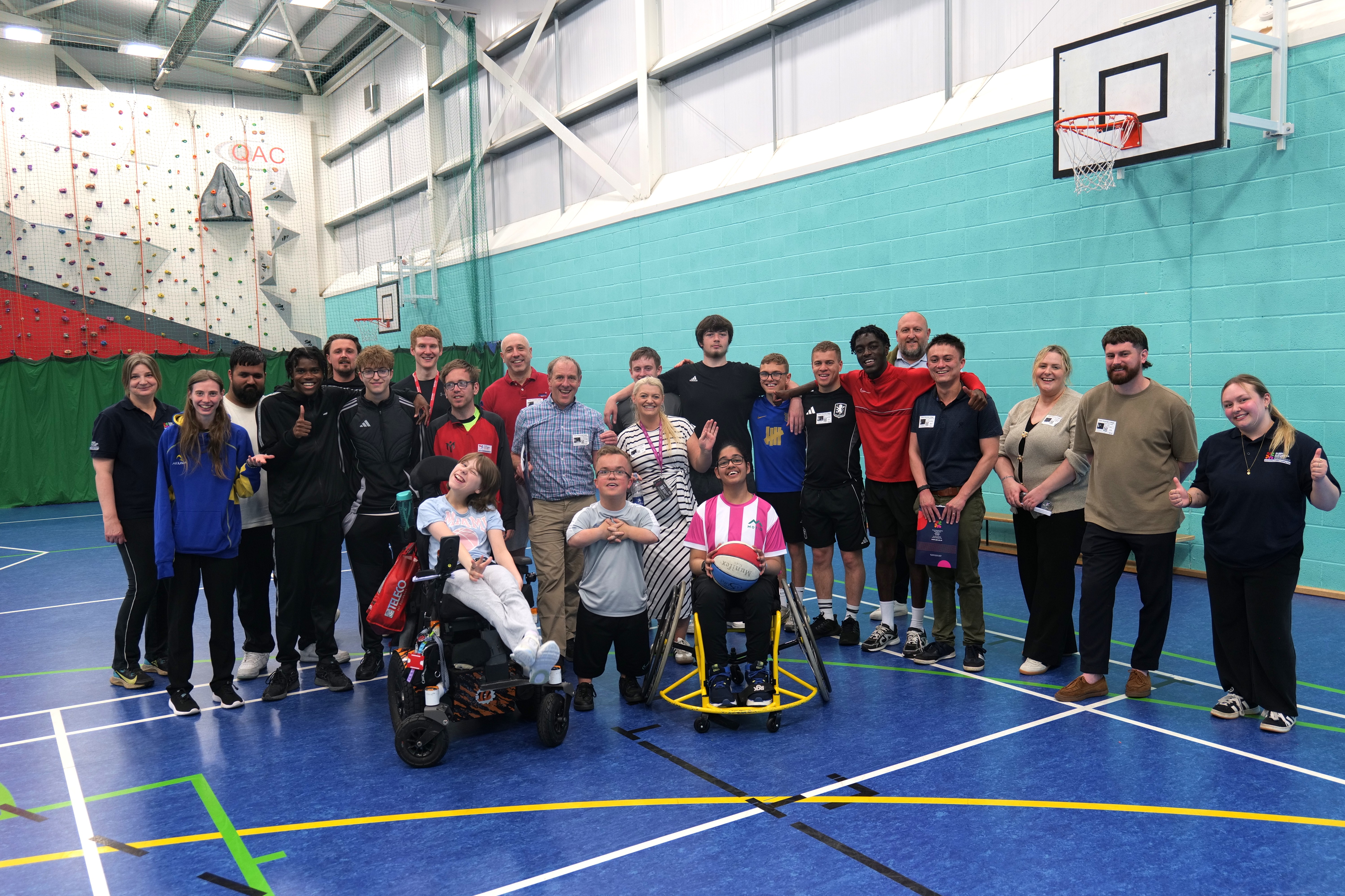 Group image of staff, students and professionals in the sports hall