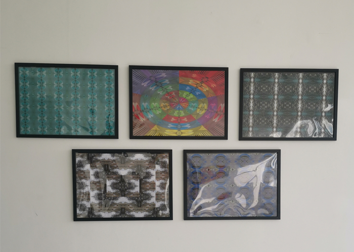 Multiple framed pieces of art created by QAC students on display at Stryx gallery