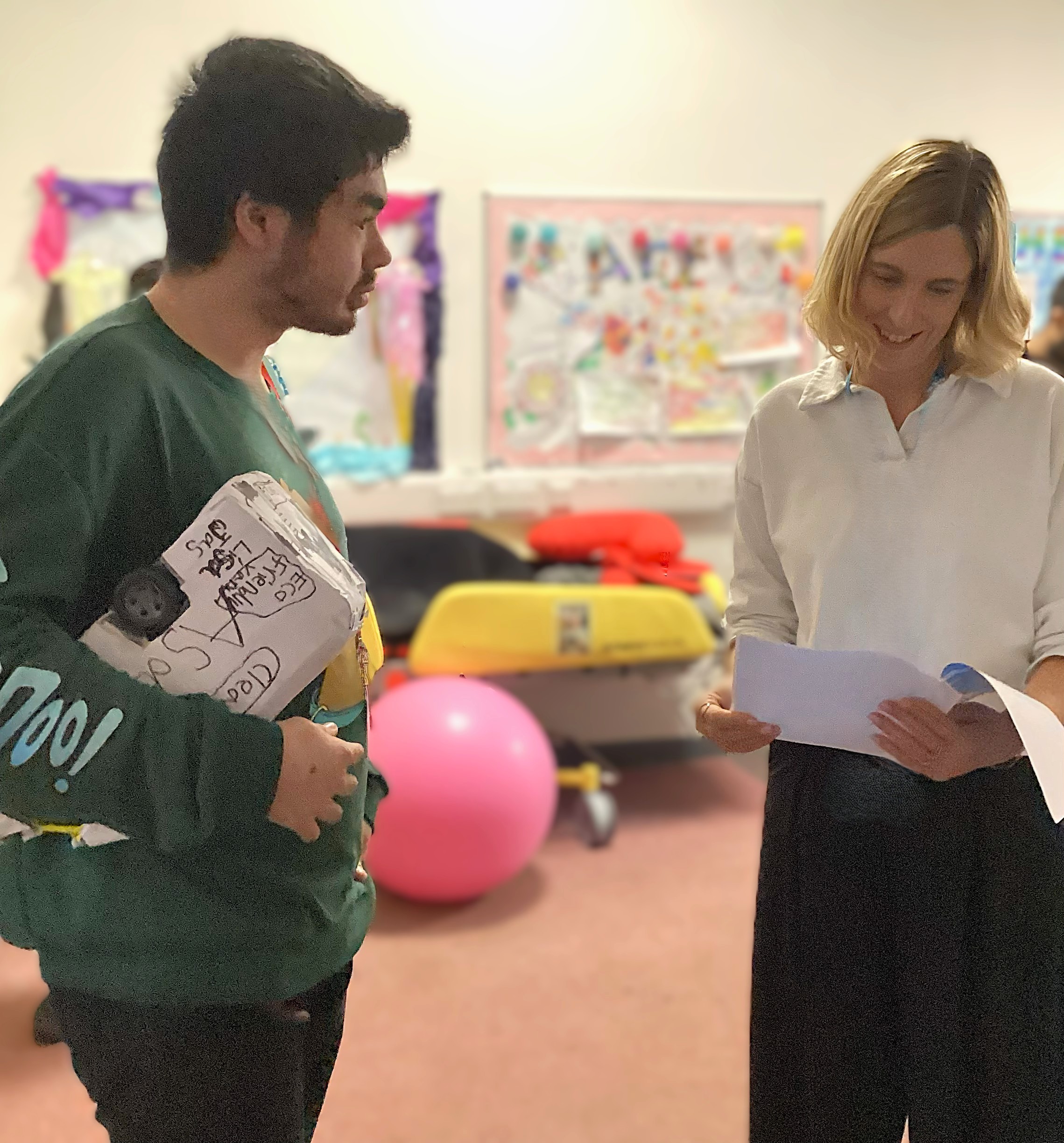 Image of a student giving a staff member a card to say thank you Image of a student giving a staff member a card to say thank you
