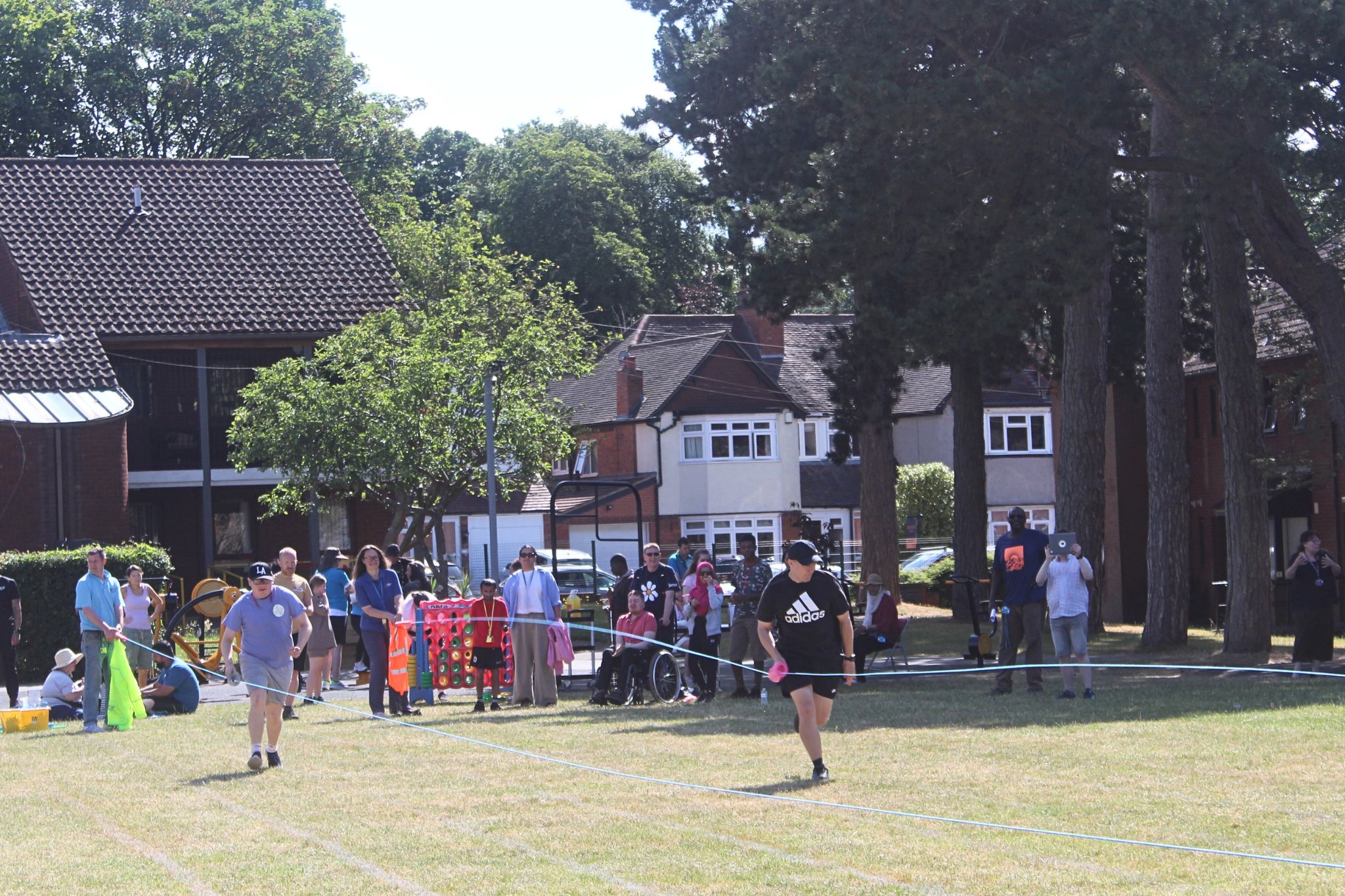 Image of two students racing holding a bottle being dragged along rope