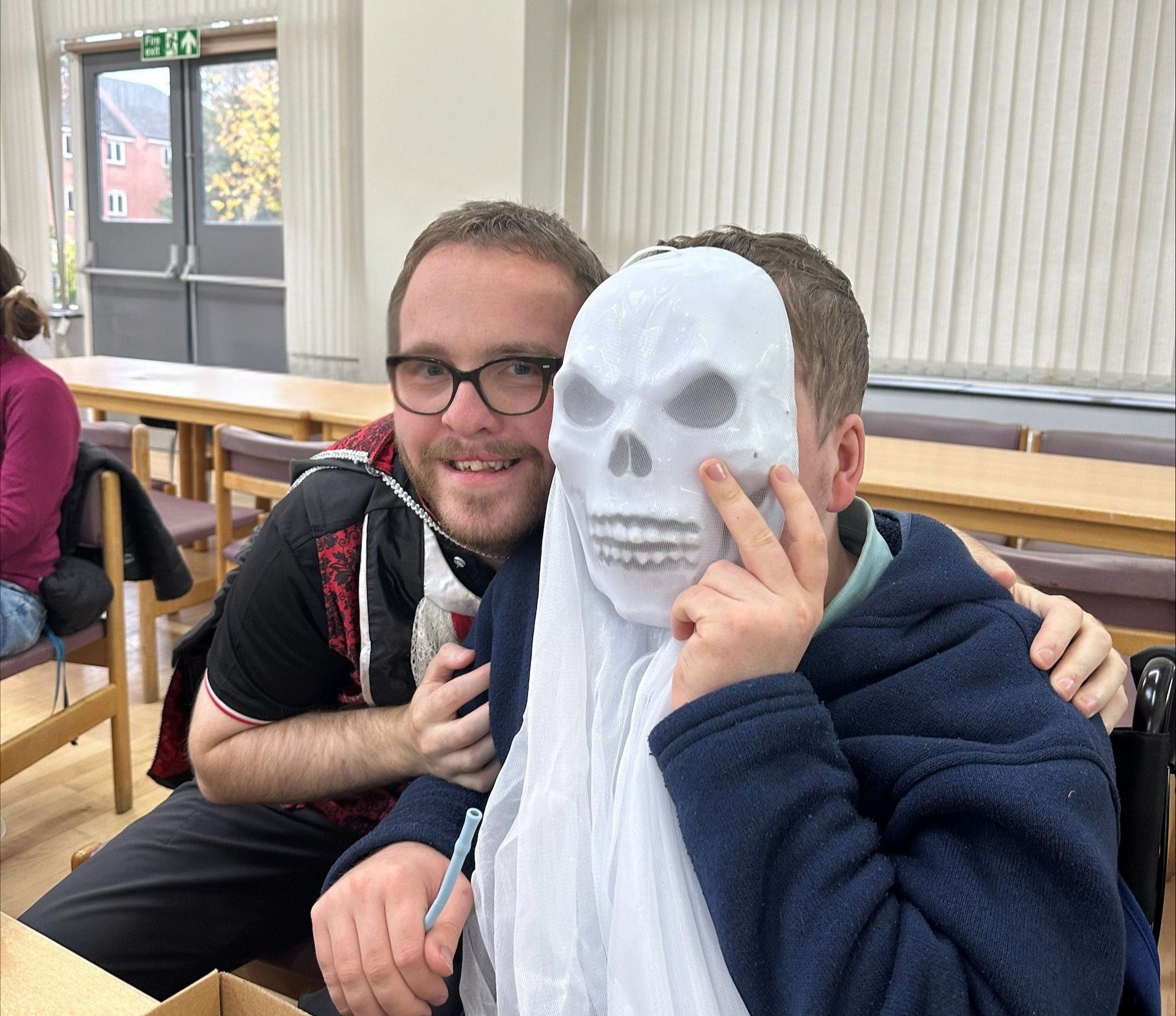 Image of 2 students smiling, one wearing a skull mask Image of 2 students smiling, one wearing a skull mask