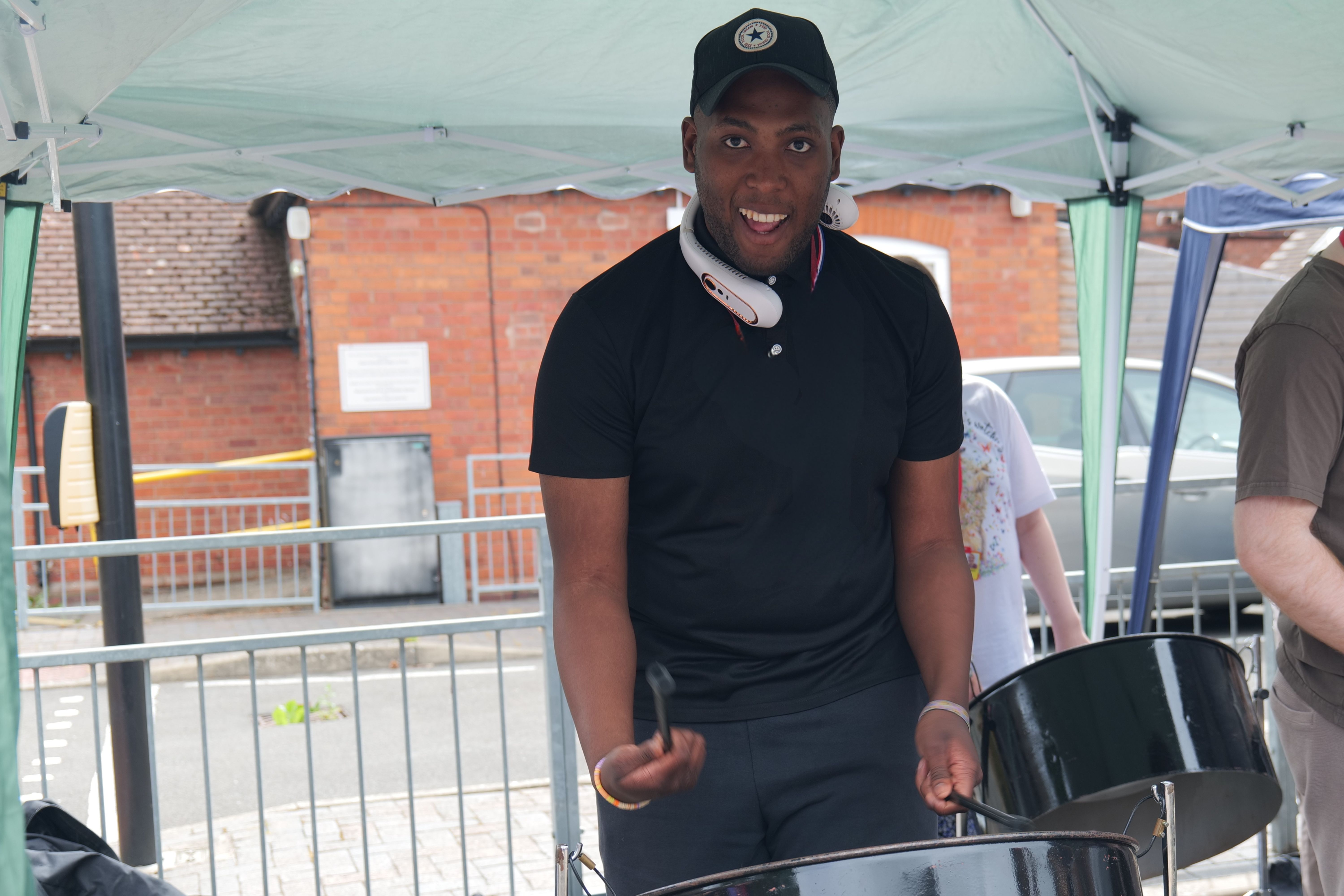Image of a student playing steel drum smiling at the camera Image of a student playing steel drum smiling at the camera