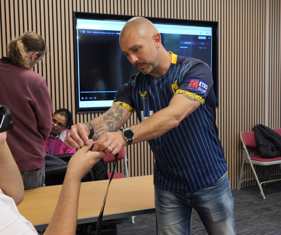 Image of Thomas assisting a student with the Give Vision Glasses Headset. /media/news/library/vg4.png