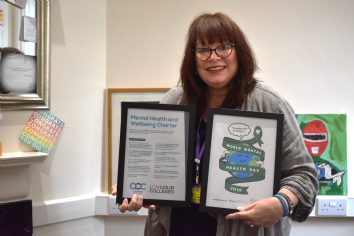 Bev Jessop holding two framed documents