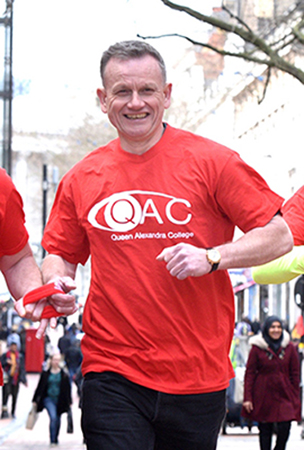 Dave Heeley running in a red QAC t-shirt