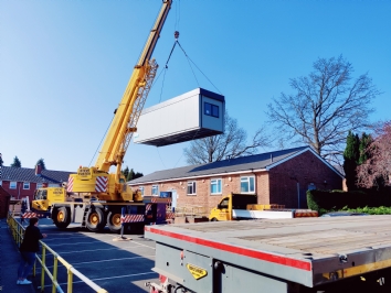 Modular building hoisted by crane