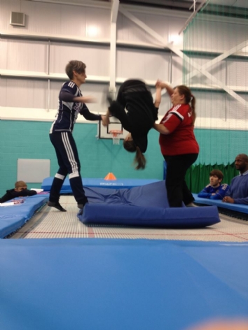 Student and instructors stand on trampoline