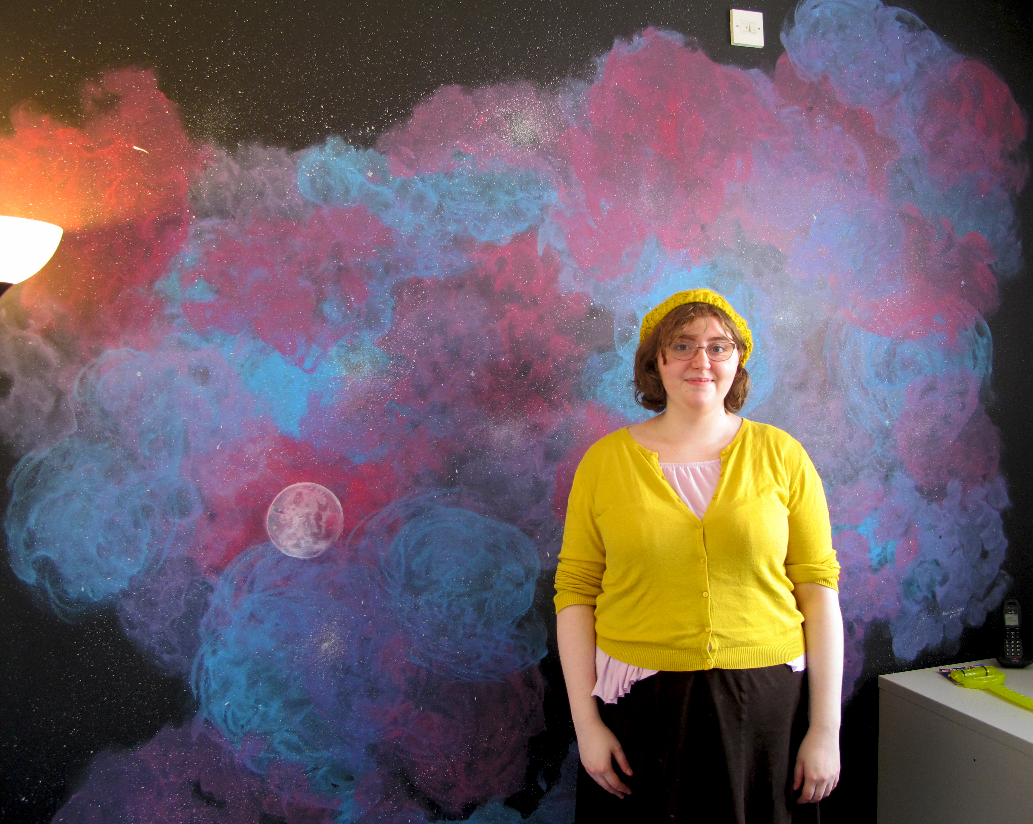 Alison next to one of her wall murals