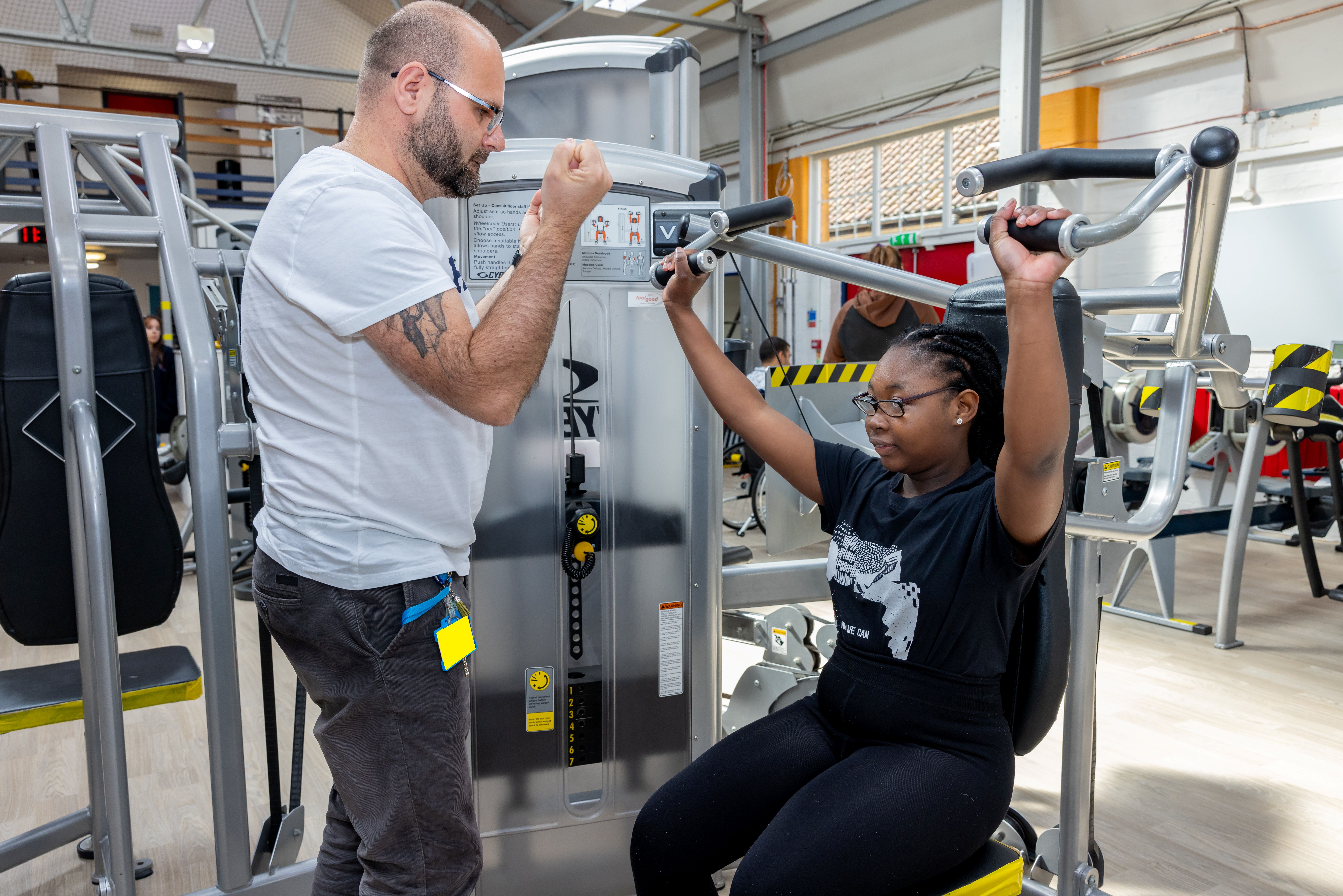 Staff member supports student in the gym